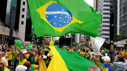 People enjoying with brazilian flag during festival in city