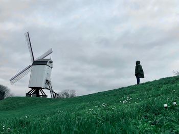 Traditional windmill on field against sky