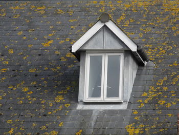 Closed white window on house roof