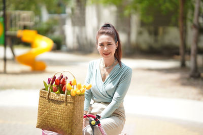 Portrait of smiling woman standing by basket