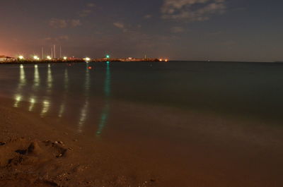Illuminated sea against sky at night