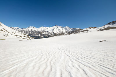 Scenic view of snowcapped mountains against clear blue sky