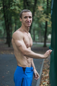 Portrait of shirtless muscular man at park