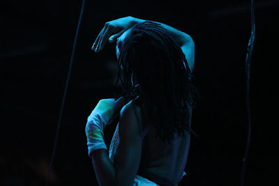 Midsection of woman standing in illuminated nightclub