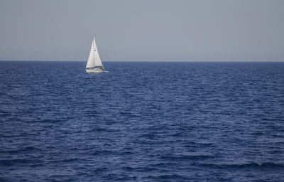 Sailboat sailing in sea against sky