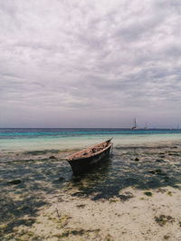 Sailboat moored on sea against sky