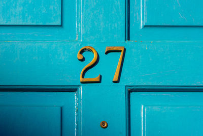 House number 27 on a blue wooden front door in london 