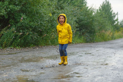Portrait of smiling boy standing in rain
