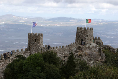 Panoramic view of flag on mountain against sky