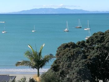 Boats sailing on sea against sky