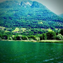 Scenic view of lake by mountains against sky