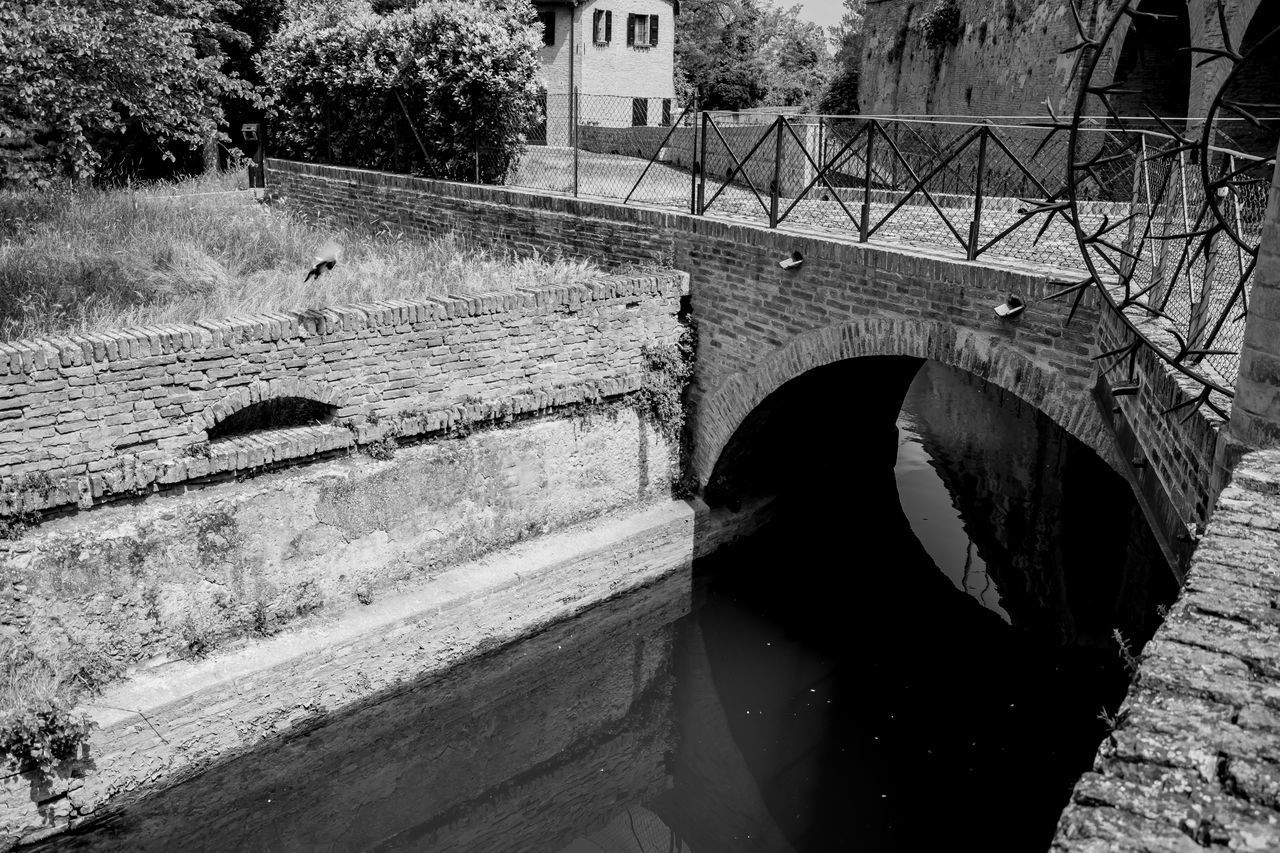 ARCH BRIDGE OVER RIVER AGAINST PLANTS