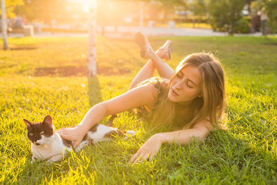 Woman lying down with dog on field
