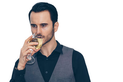 Portrait of mid adult man holding drink against white background