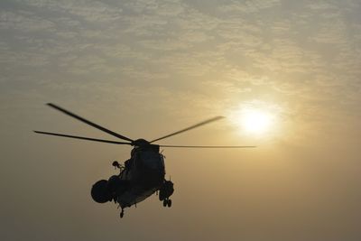 Low angle view of helicopter against sunset