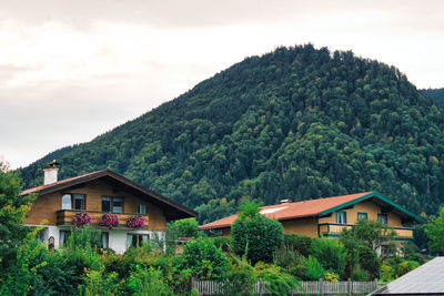 House amidst trees and mountains against sky