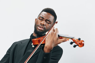 Portrait of man playing violin against white background