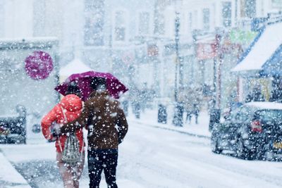 Couple walking on road during snowfall