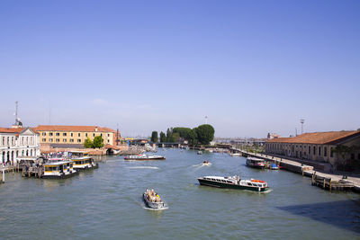 Boats sailing in river in city