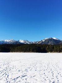 Scenic view of frozen landscape against clear blue sky