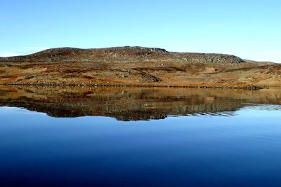 Reflection of mountains in lake against clear blue sky