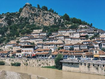 Buildings by river against sky