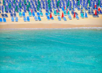 Empty blue chairs at beach during summer