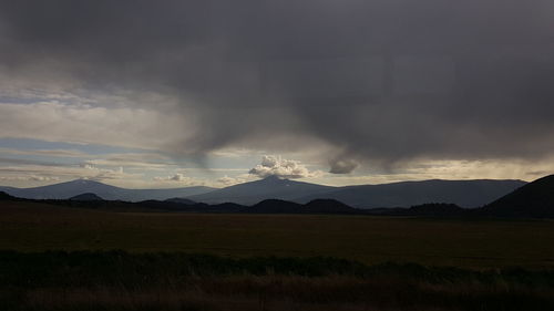 Scenic view of mountains against cloudy sky