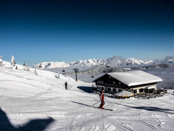 People walking on snow covered landscape