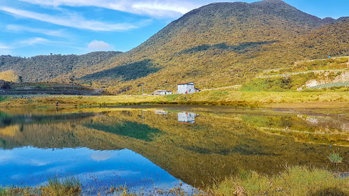 Scenic view of lake by mountain against sky