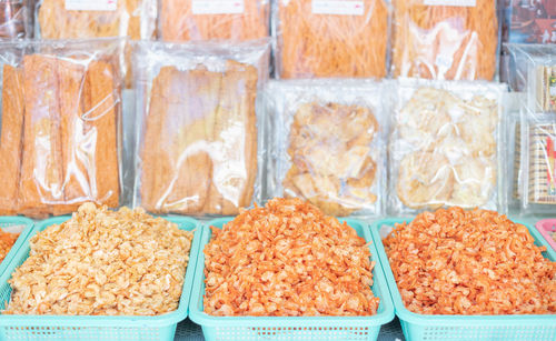 Dried shrimp in a green basket are preparing for sale at the seafood market.