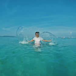 Person swimming in sea against sky