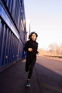 Full length of woman jogging on road