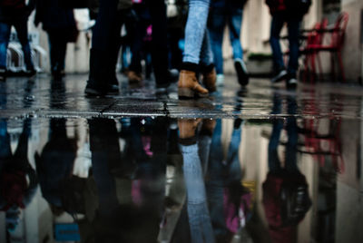 Low section of people walking by puddle