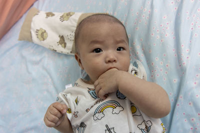 Portrait of cute baby lying on bed