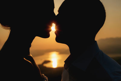 Silhouette man with sun during sunset