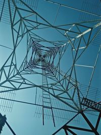 Low angle view of electricity pylon against blue sky