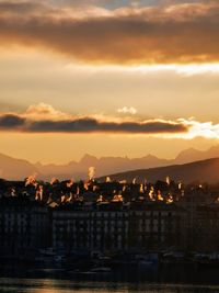 Silhouette buildings in city against sky during sunset