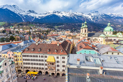 Aerial view of innsbruck old town shows famous goldenes dachi and snow mountain ranges background