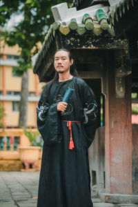 Portrait of young woman standing in city