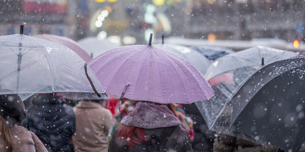 People walking on wet road during rainy season