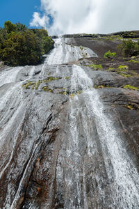 Scenic view of waterfall against sky