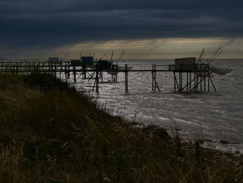 Pier over sea against sky during sunset