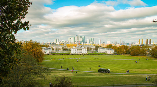 Scenic view of field by buildings against sky