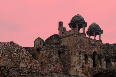 Low angle view of old building against sky during sunset