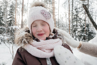 Little girl in the snow in the winter forest