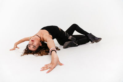 Young woman lying down against white background