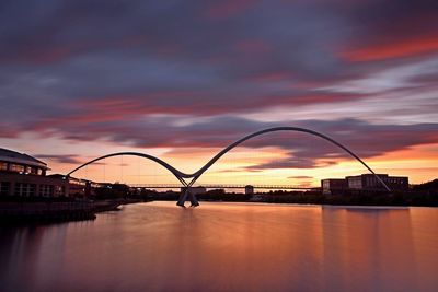 Bridge over river against sky during sunset