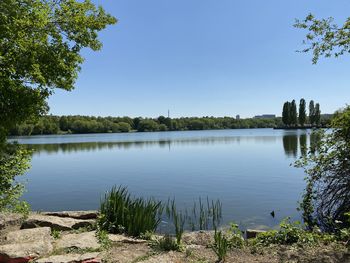 Scenic view of lake against clear blue sky