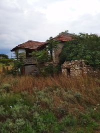 Abandoned house on field against sky